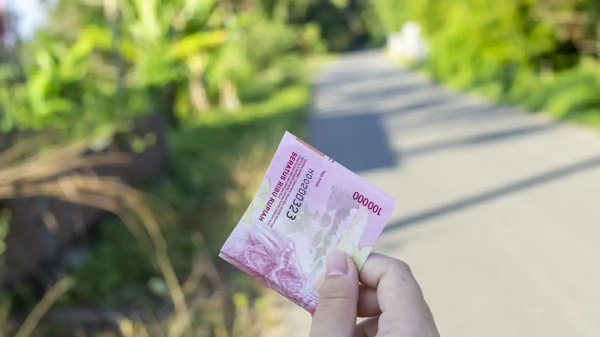 Tangan memegang uang kertas rupiah