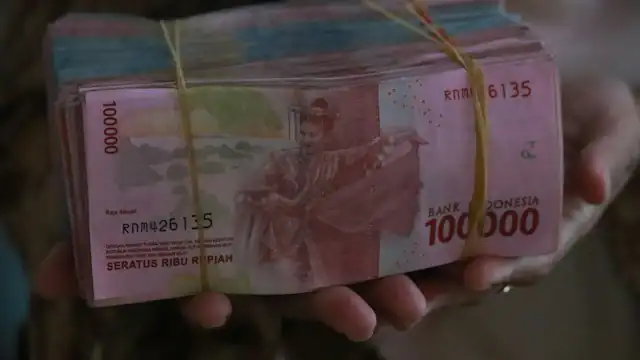Tangan memegang uang rupiah