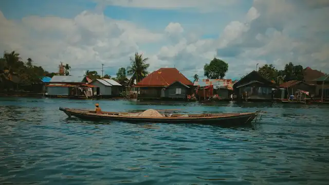 Perahu di sungai dekat rumah warga