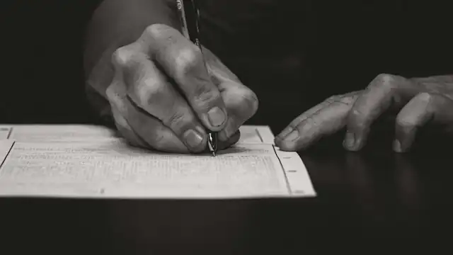 Tangan menulis dengan pena tinta