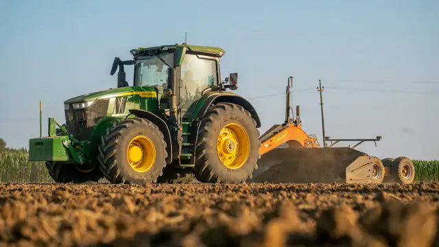 Traktor membajak lahan